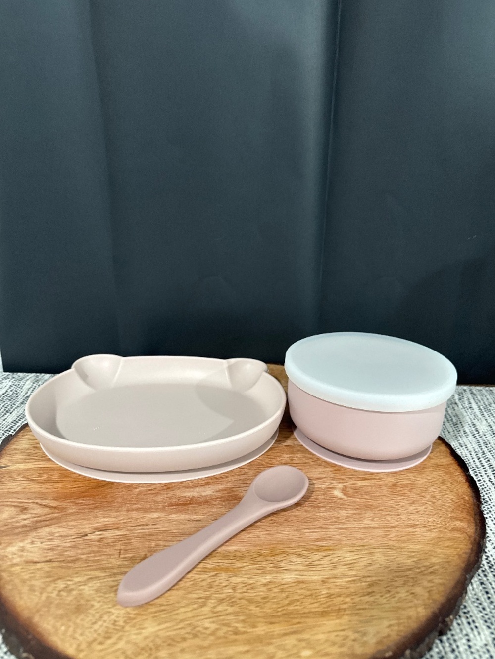 Pink silicone baby plate, bowl with lid, and a spoon.